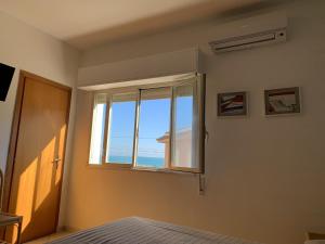 a bedroom with a window with a view of the ocean at Hotel Il Triangolo in Agnone Bagni