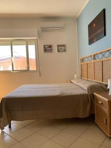 a bedroom with a bed and a tv on the wall at Hotel Il Triangolo in Agnone Bagni