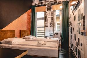 duas camas num quarto com cartazes na parede em Chillout Hostel Zagreb em Zagreb