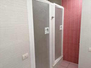 a shower stall in a bathroom with red tiles at Hello Villarreal Pension in Villareal