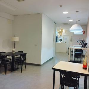 a dining room with tables and chairs and a white wall at Hello Villarreal Pension in Villareal