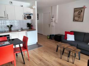 een keuken en een woonkamer met een bank en een tafel bij charmant T2 formiguères les esplaneilles in Formiguères