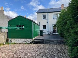 a green building in front of a house at 3 Bedroom Culduthel House Free Parking in Inverness