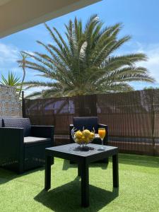 un tavolo con un cesto di frutta e due bicchieri di La palmera a Frontignan