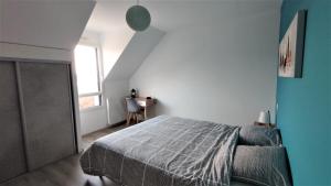 une chambre avec un lit et un mur bleu dans l'établissement La villa Breizh 'île, à Saint-Gildas-de-Rhuys