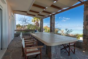 un patio al aire libre con una gran mesa de piedra y sillas en Dream House, en Áyioi