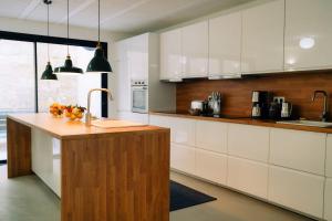 cocina con armarios blancos y encimera de madera en Outsite Bordeaux en Burdeos