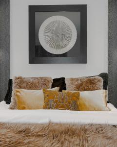 uma cama branca com almofadas e uma fotografia na parede em Cool Covent Garden Theatre Design Hub for Families Friends Couples em Londres