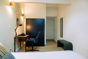 um quarto com uma cama, uma secretária e uma cadeira em Outsite Bordeaux em Bordeaux