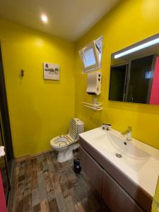 a yellow bathroom with a toilet and a sink at GÎTE LES VOLETS BLEUS in Yport