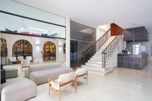 sala de estar con escalera y muebles blancos en Hotel Posada Del Sol en Salta