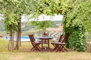 a table and chairs under an umbrella near a pool at Villa Ginevra by Tenuta di Ghizzano in Ghizzano