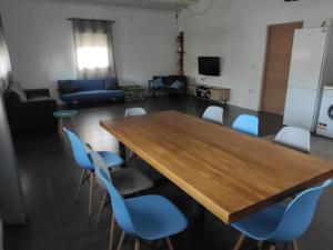 una sala de conferencias con una mesa de madera y sillas azules en Chalet en el Aljarafe a 15 min de Sevilla, en Sevilla