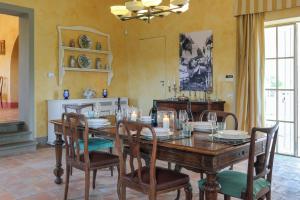 a dining room with a wooden table and chairs at Villa Ginevra by Tenuta di Ghizzano in Ghizzano