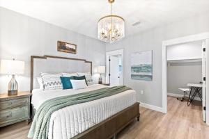 a bedroom with a large bed and a chandelier at Brand New Entire Home close to beach in St. Augustine