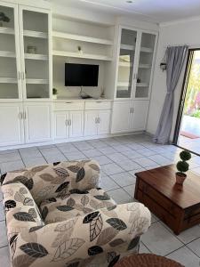 een woonkamer met een bank en een tv bij Mtunzi Park, 39 Peaceful shores in Scottburgh