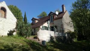 una grande casa bianca con una scala davanti di Moulin en bord de rivière - 1 à 5 pers - logement atypique-linge-wifi a Chevillon-sur-Huillard