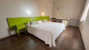 1 dormitorio con 1 cama grande y cabecero verde en Hotel Posada Del Sol en Salta