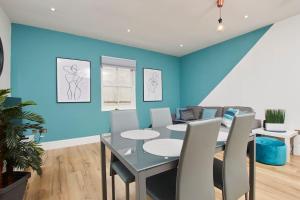a dining room with a table and a blue wall at Beautiful Central Apartment in Leamington Spa
