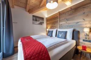 a bedroom with a large bed with a wooden wall at AlpenParks Premium Apartment Rehrenberg II in Viehhofen