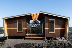 a small house with a porch and stairs to it at THE OHANA HOUSE, Amazing Tiny Home on A Volcanic Lava Field! in Kehena
