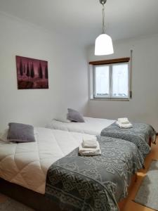 1 dormitorio con 2 camas y ventana en PENICHE - Guest House Casa das Estelas en Peniche