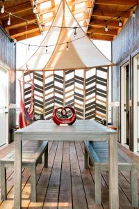 a picnic table with benches on a wooden deck at THE OHANA HOUSE, Amazing Tiny Home on A Volcanic Lava Field! in Kehena