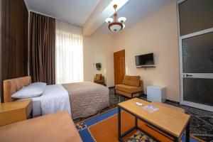 Cette chambre comprend un lit et une télévision. dans l'établissement Hotel Pik Loti, à Tirana