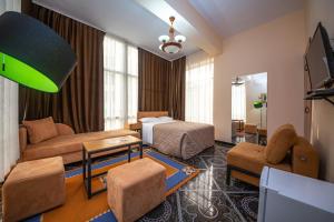 - un salon avec un lit et un canapé dans l'établissement Hotel Pik Loti, à Tirana