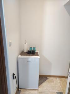 a small white refrigerator with two cups on top of it at panos hause in Kastrákion