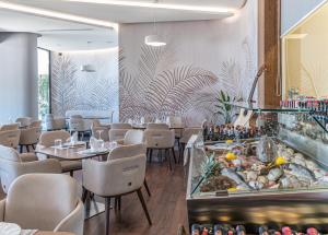 a restaurant with tables and chairs and a fish tank at Yacht Hotel in Vlorë