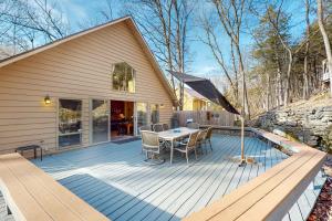 a wooden deck with a table and an umbrella at Urban Deck House in Eureka Springs