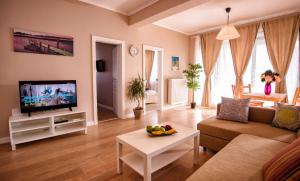 ein Wohnzimmer mit einem Sofa und einem TV in der Unterkunft Aquarium Residence 2 in Mamaia Nord – Năvodari