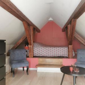Zimmer mit 2 Stühlen und einem Bett im Dachgeschoss in der Unterkunft Gite Joël et Nathalie in Urschenheim