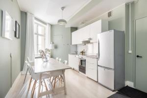 cocina con nevera blanca y mesa en Comfortable city home, en Helsinki
