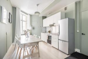 eine Küche mit einem weißen Kühlschrank und einem Tisch in der Unterkunft Comfortable city home in Helsinki