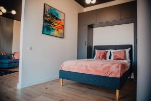 een slaapkamer met een bed met een schilderij aan de muur bij JBHotels Apartament Premium Hanza Tower in Szczecin