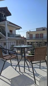 un patio con tavolo e sedie sul balcone. di MAGDALINOS APPARTMENTS (4) a Nea Skioni