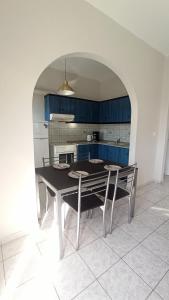 una cucina con tavolo da pranzo e armadi blu di MAGDALINOS APPARTMENTS (4) a Nea Skioni