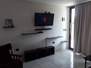 een woonkamer met een flatscreen-tv aan de muur bij Casa moderna estilo minimalista muy luminosa in San Javier