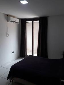 een slaapkamer met een zwart bed en een raam bij Casa moderna estilo minimalista muy luminosa in San Javier