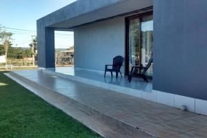 een patio met twee stoelen aan de zijkant van een huis bij Casa moderna estilo minimalista muy luminosa in San Javier