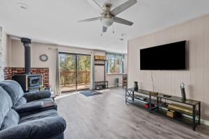 a living room with a couch and a flat screen tv at Big Trees, Little Cabin in Arnold