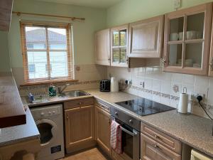 a kitchen with a sink and a washing machine at Two Bedroom Glen View Free Parking in Inverness