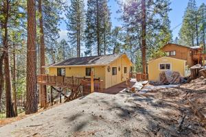 ein gelbes Haus mitten im Wald in der Unterkunft Big Trees, Little Cabin in Arnold