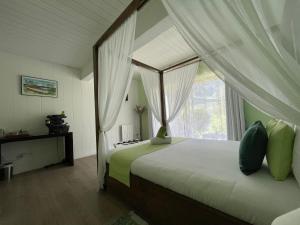 um quarto com uma cama de dossel e uma janela em La Villa Soalic em Cilaos