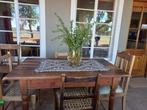 a vase of flowers sitting on a wooden table at Koha Guesthouse in Mariental