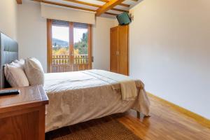 - une chambre avec un lit et une fenêtre dans l'établissement Apartamento Otoño 2 - Apartamentos Nature, à Cangas del Narcea