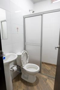 a bathroom with a shower and a toilet and a sink at Hotel Media Luna in Cúcuta