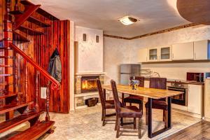 cocina con mesa de madera y algunas sillas en Вили Forest Nook, en Pamporovo